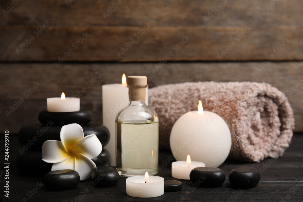 Spa composition with candles on wooden table