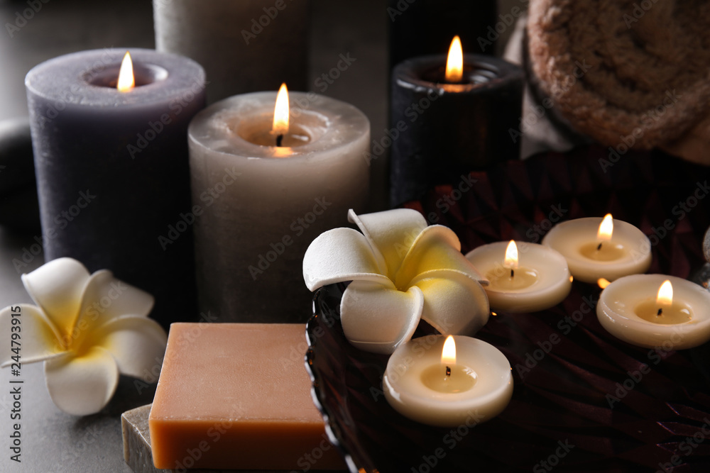Spa composition with candles and cosmetic on table