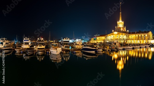 Marine Station of Sochi  illuminated with lights at night with reflection in water