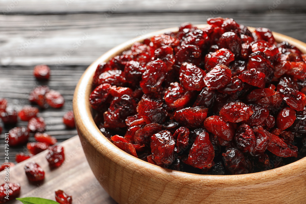 Bowl with cranberries on wooden table, closeup. Dried fruit as healthy snack Bowl with cranberries on wooden table, closeup. Dried fruit as healthy snack