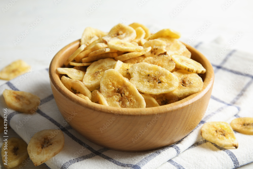 Wooden bowl with sweet banana slices on table. Dried fruit as healthy snack Wooden bowl with sweet banana slices on table. Dried fruit as healthy snack