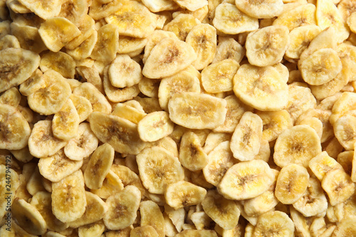Sweet banana slices as background, top view. Dried fruit as healthy snack