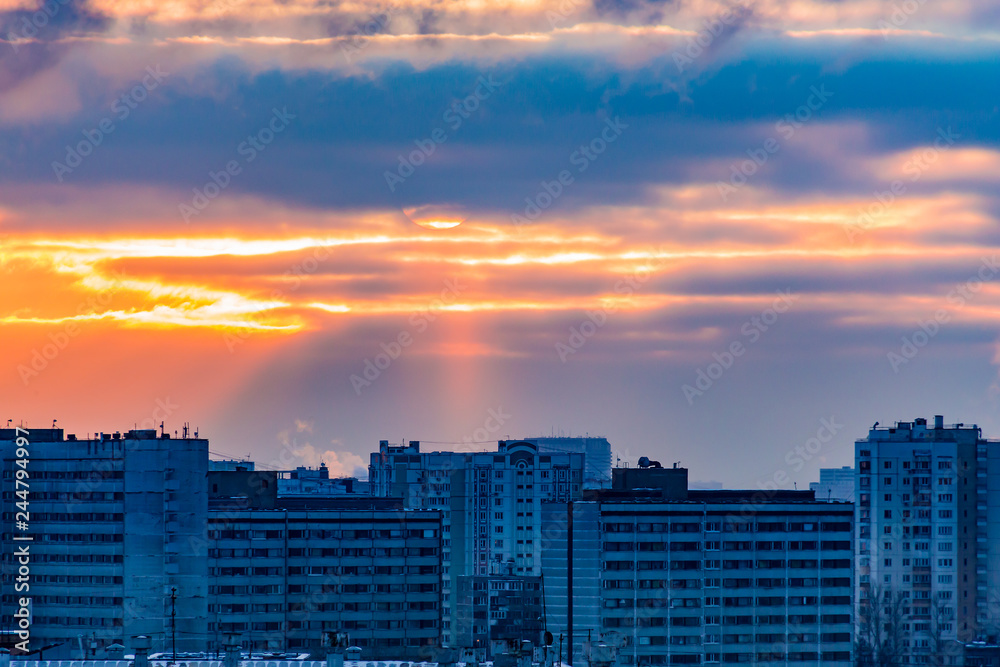 Sunny sunset over the city. Winter day. Various architectural structures. Sun, sky and clouds. Sunny sunset over the city. Winter day. Various architectural structures. Sun, sky and clouds.