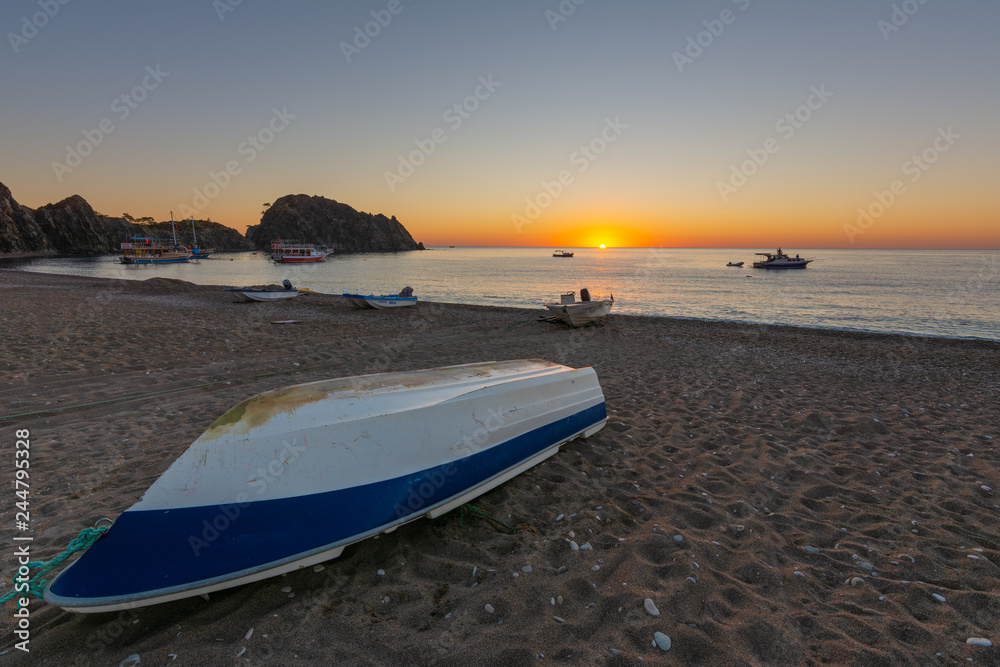 Sunrise on the Mediterranean coast, against the background of fishing boats.