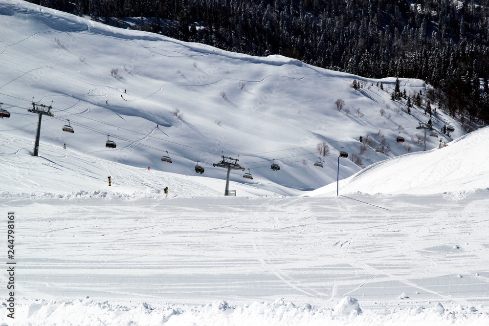 Obraz premium Skiers and snowboarders on chairlift, ski resort Rosa Khutor, Sochi Russia