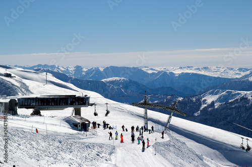 Skiers and snowboarders riding on a ski slope in mountain resort snowy winter, ski resort Rosa Khutor, Sochi © KonstantinM