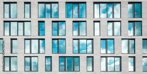 Leinwand Poster modern office building facade , window facade with sky reflection -