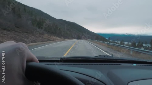 Driving POV on top of a mountains peak. The window view is larger mountains in the distance. photo