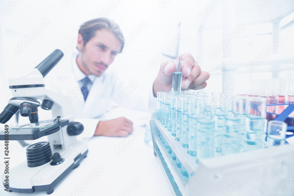 Chemist looking at test-tubes with blue liquids Chemist looking at test-tubes with blue liquids