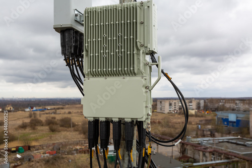 Outdoor remote radio unit of GSM DCS UMTS LTE is as part of communication equipment of basic station are installed on the tubular mast on the roof photo