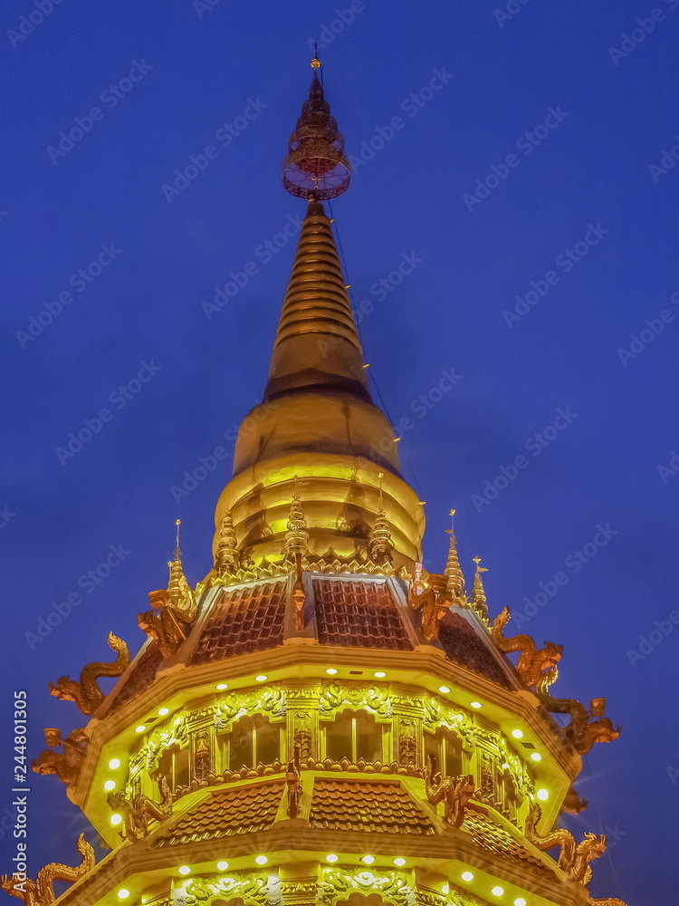 Fototapeta premium Beautiful Top of Pagoda chinest style decorate with lighting at night with cloudy sky background, Wat Huay Pla Kang, Chiang Rai, Thailand