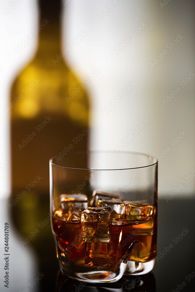 Gorgeous view of glass of alcohol drink with ice on shadow of bottle background. Beautiful backgrounds. Gorgeous view of glass of alcohol drink with ice on shadow of bottle background. Beautiful backgrounds.