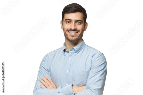 Modern businessman in blue shirt standing with crossed arms, isolated on white background