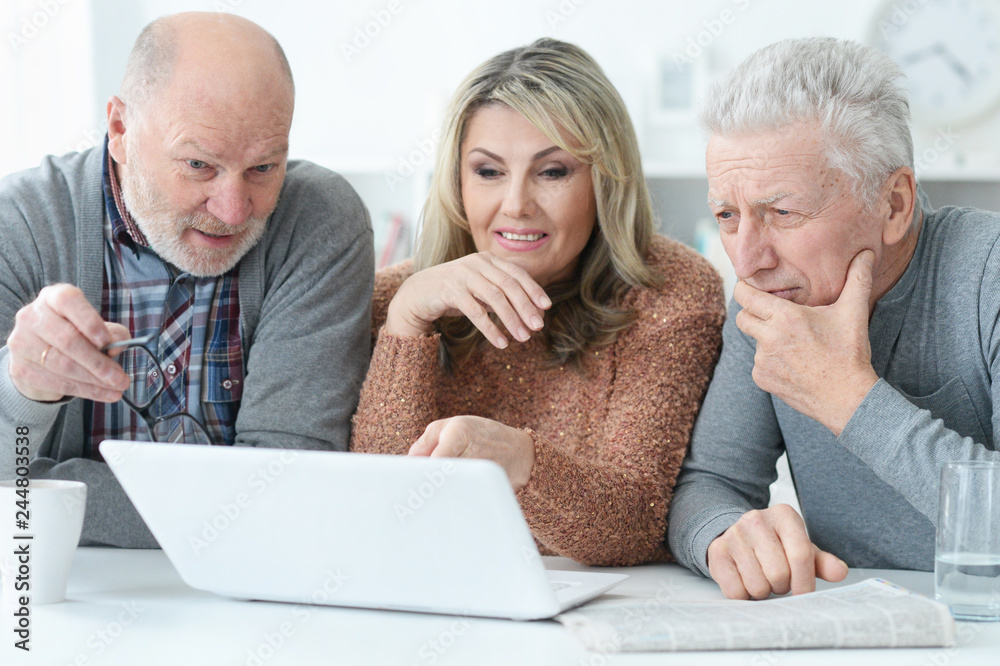 senior people sitting at table and looking at laptop senior people sitting at table and looking at laptop