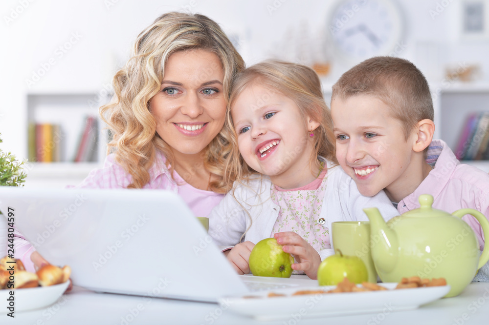 happy mother and children sitting at table happy mother and children sitting at table