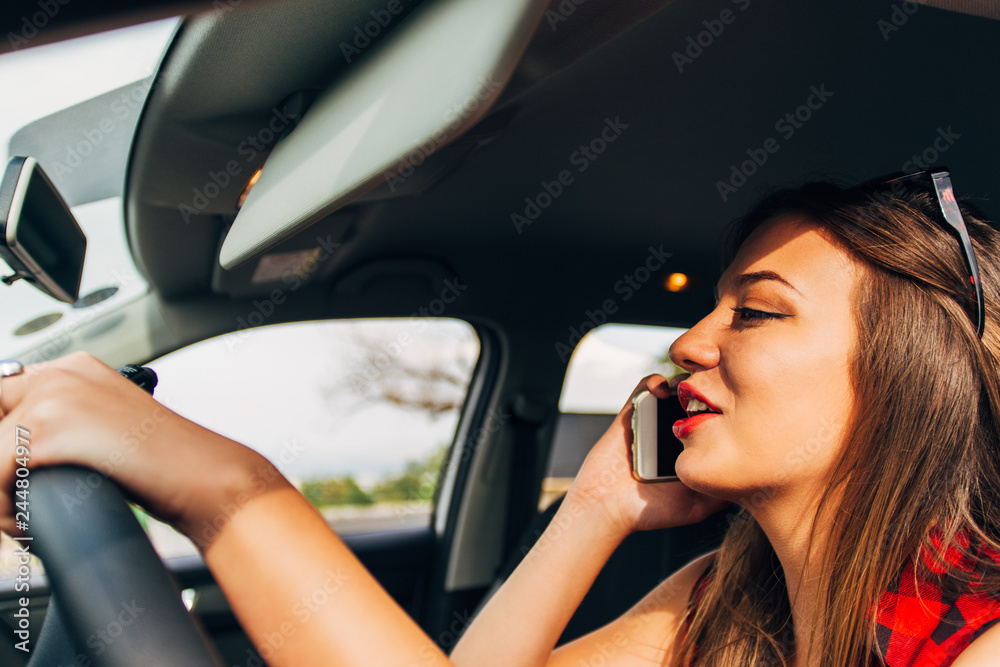 Woman in risk driving holding and talking at her cellphone