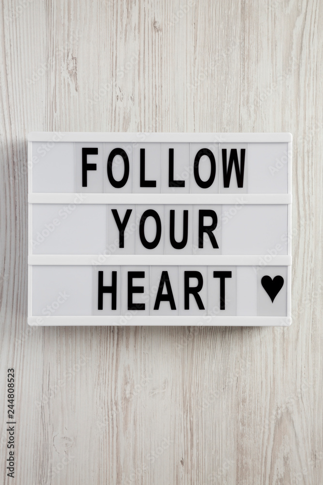 Modern board with text 'Follow your heart' on a white wooden background, top view. Flat lay, overhead. Valentine's Day 14 February. Modern board with text 'Follow your heart' on a white wooden background, top view. Flat lay, overhead. Valentine's Day 14 February.