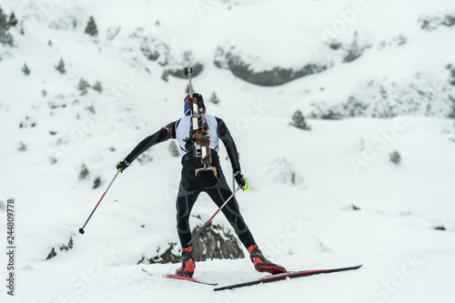 Winter sports. A participant in a biathlon competition, in a winter season in Spain, in a snowy landscape.