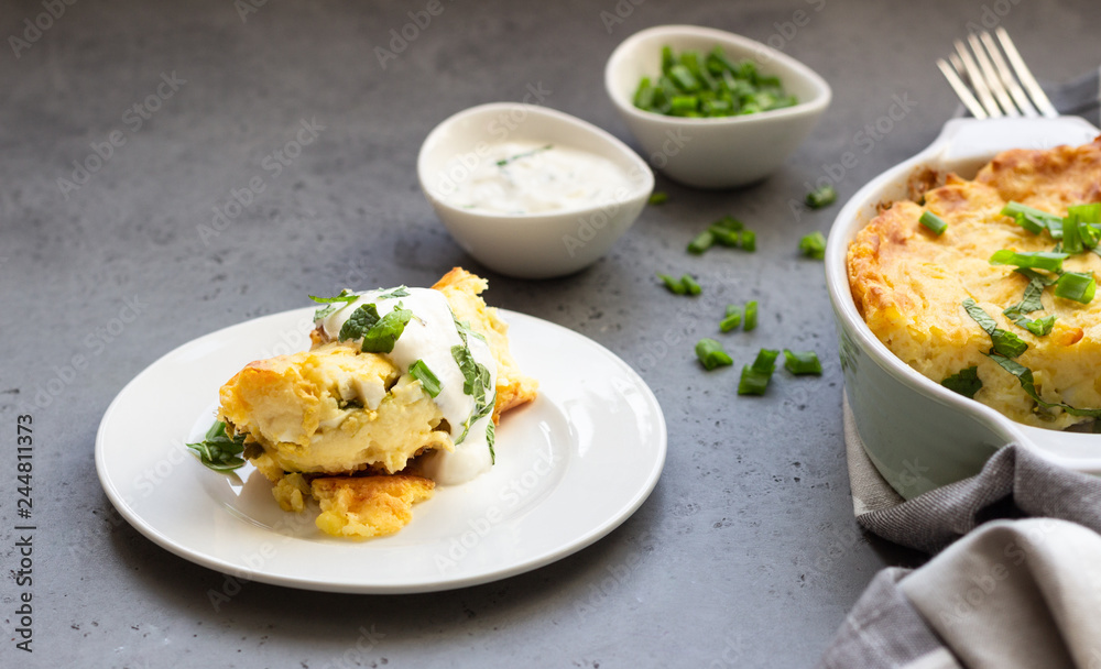 Potatoes casserole with cheese and green onion served with sour cream and mint. Vegetarian food. Copy space. Potatoes casserole with cheese and green onion served with sour cream and mint. Vegetarian food. Copy space.