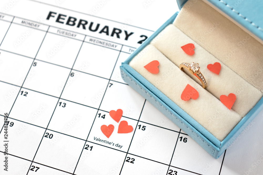 Valentine's day, February 14 on the calendar with red hearts and wedding ring in blue box. Offer to marry Valentine's day, February 14 on the calendar with red hearts and wedding ring in blue box. Offer to marry