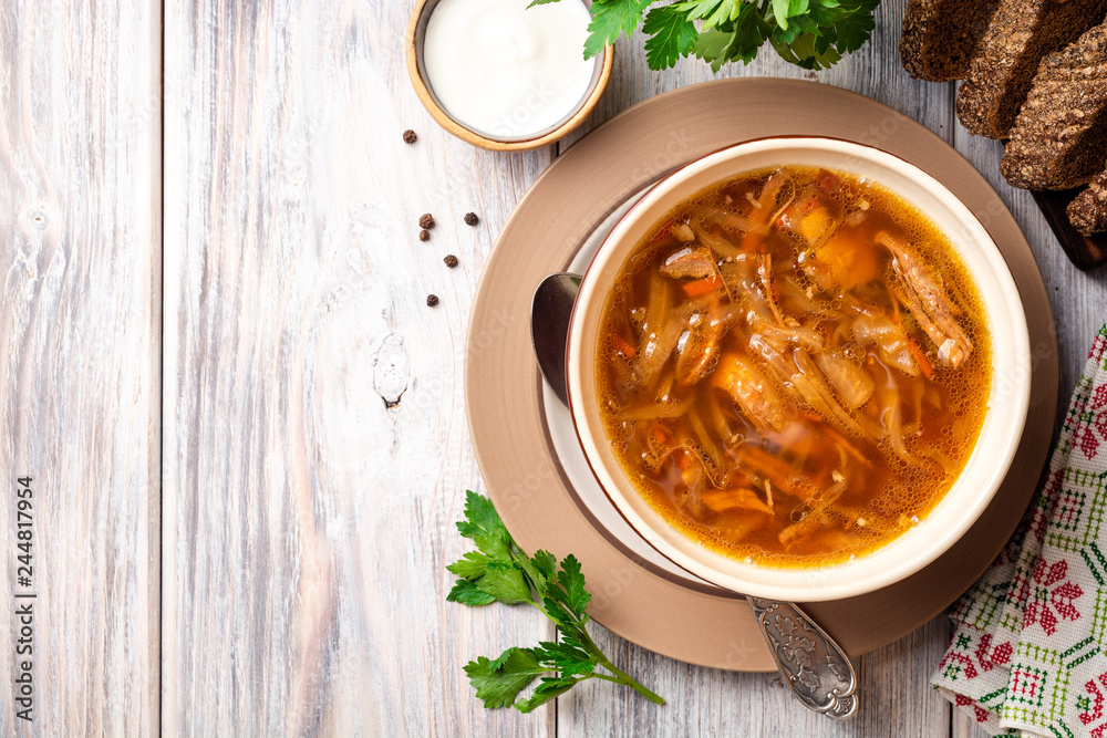 Traditional Russian sauerkraut soup Shchi in bowl on rustic wooden background. Top view. Copy space.