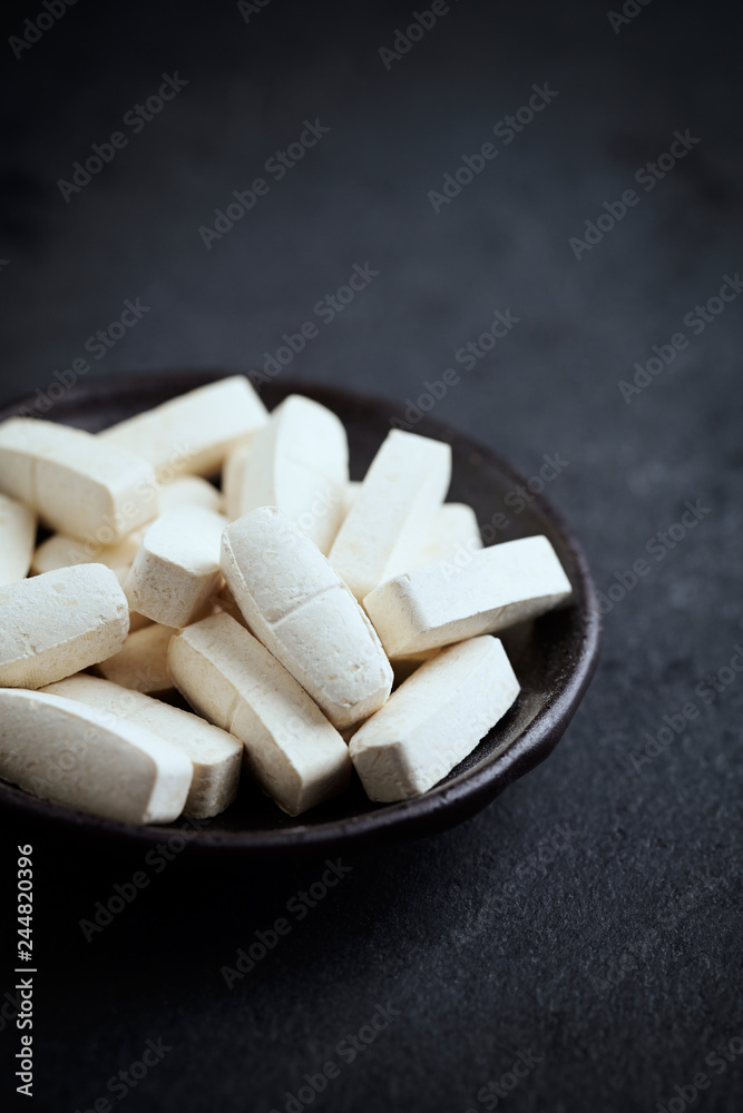 BCAA amino acids. Nutrition for bodybuilding. Fitness supplements on black stone background. Close up. Copy space. BCAA amino acids. Nutrition for bodybuilding. Fitness supplements on black stone background. Close up. Copy space.
