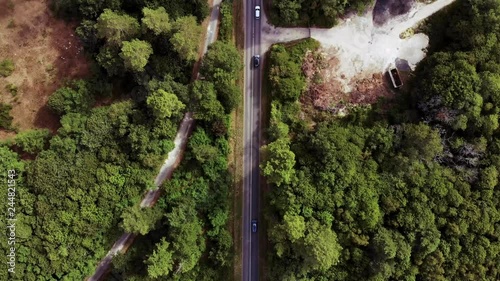 Aerial reveal shot of a French village from a road in the forest taken from a drone