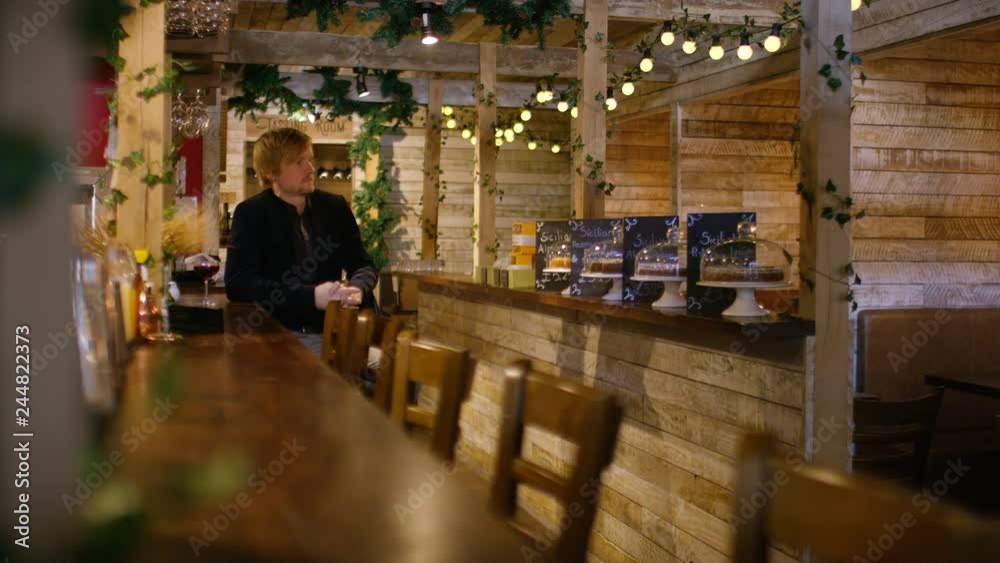Lone man waiting for his date to turn up at the bar, then she arrives Lone man waiting for his date to turn up at the bar, then she arrives