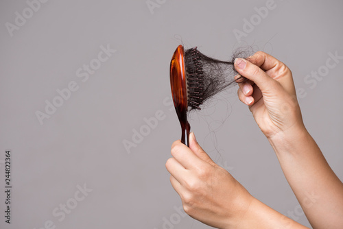 Healthcare concept. Woman show her brush with long loss hair and pulling her hair from brush. photo