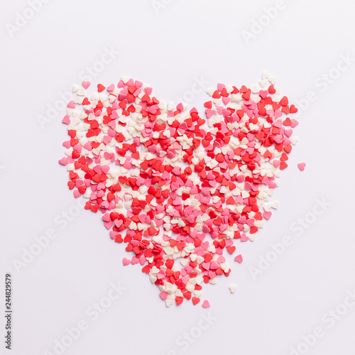 Red  pink and white heart shaped sweets in the shape of a heart scattered on white background. space for text. flat lay. valentine concept