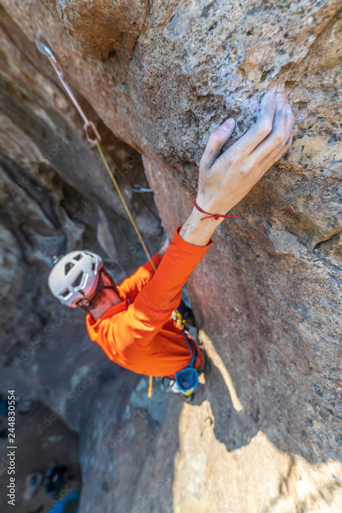 Obraz premium The last movements to reach the summit by a male climber. Rock climbing inside Andes mountains and valleys at Cajon del Maipo, an amazing place to enjoy rock climbing and mountaineering sports, Chile