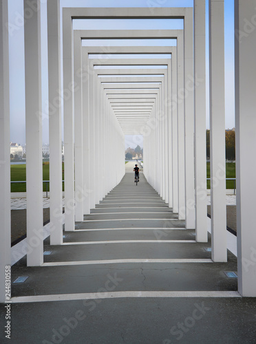 Colonnades with unicyclist in the background. Entrance to the floating meadow in Schwerin. Germany photo