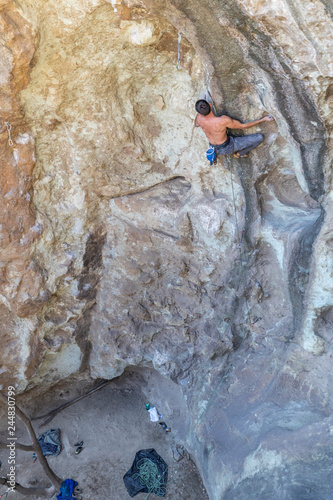 The last movements to reach the summit by a male climber. Rock climbing inside the Andes mountains at Cajon del Maipo, Chile. Climber solving the movements of "Annunaki" route a 8b french difficulty