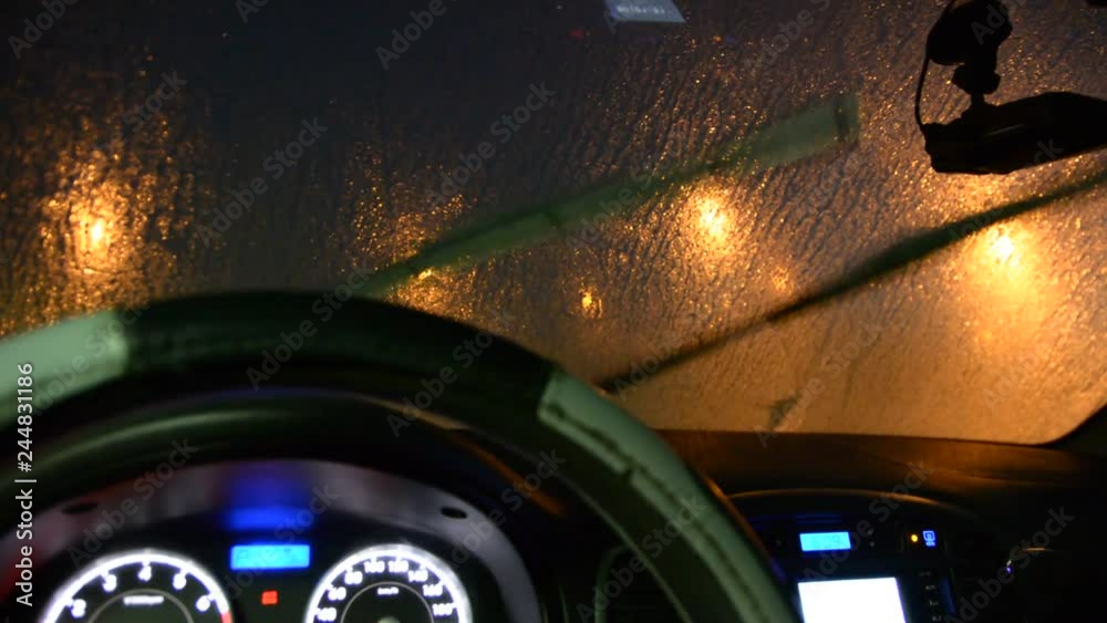 windscreen wiper can't remove ice from the windshield. view from inside of car night low light.
