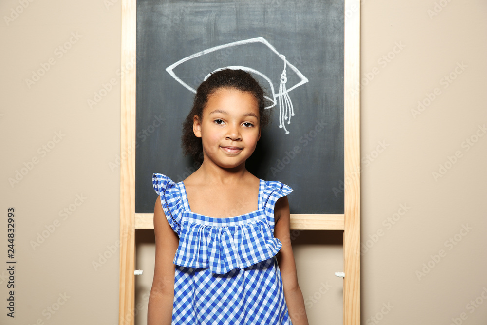 © New Africa - African-American child standing at blackboard with chalk drawn academic cap. Education concept © New Africa - African-American child standing at blackboard with chalk drawn academic cap. Education concept