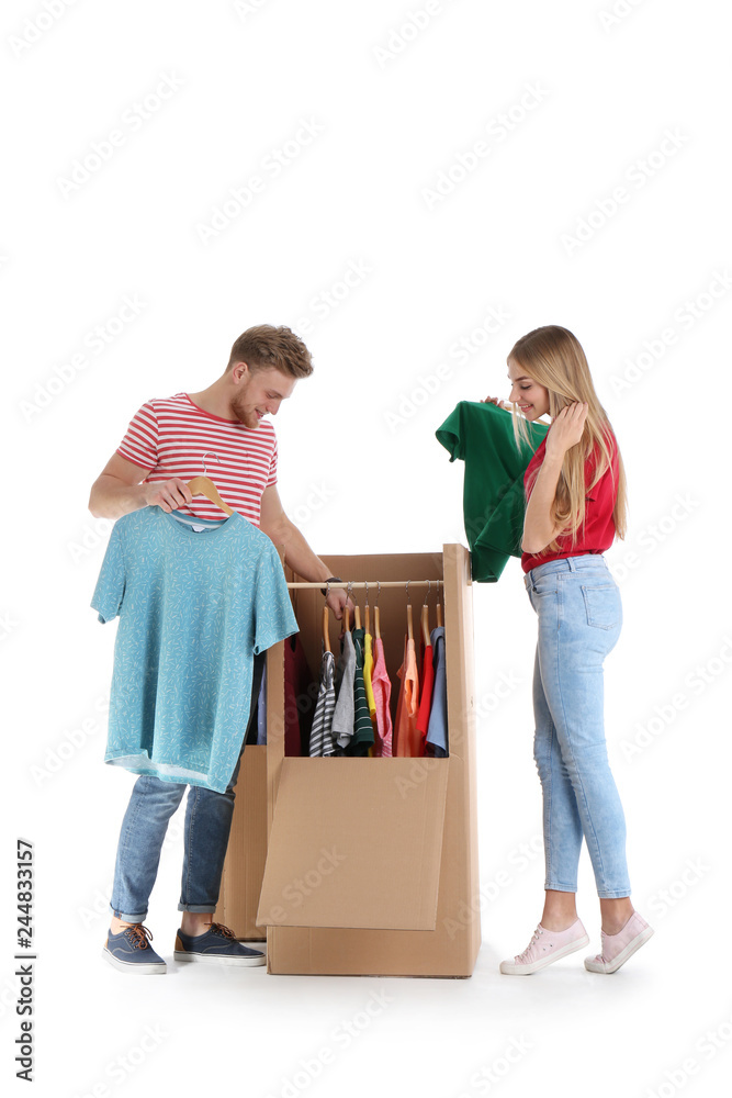 Young couple near wardrobe boxes on white background Young couple near wardrobe boxes on white background