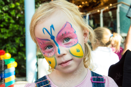 portrait of a child with a butterfly on the face, vertically