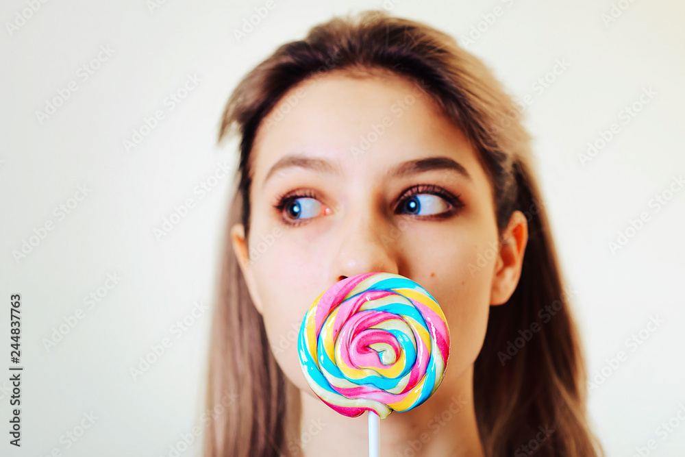 Portrait of attractive girl with colored, sweet caramel candy.