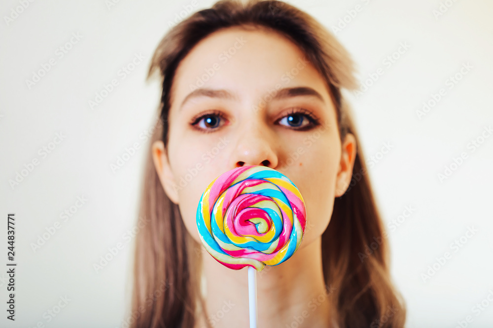 Portrait of attractive girl with colored, sweet caramel candy.