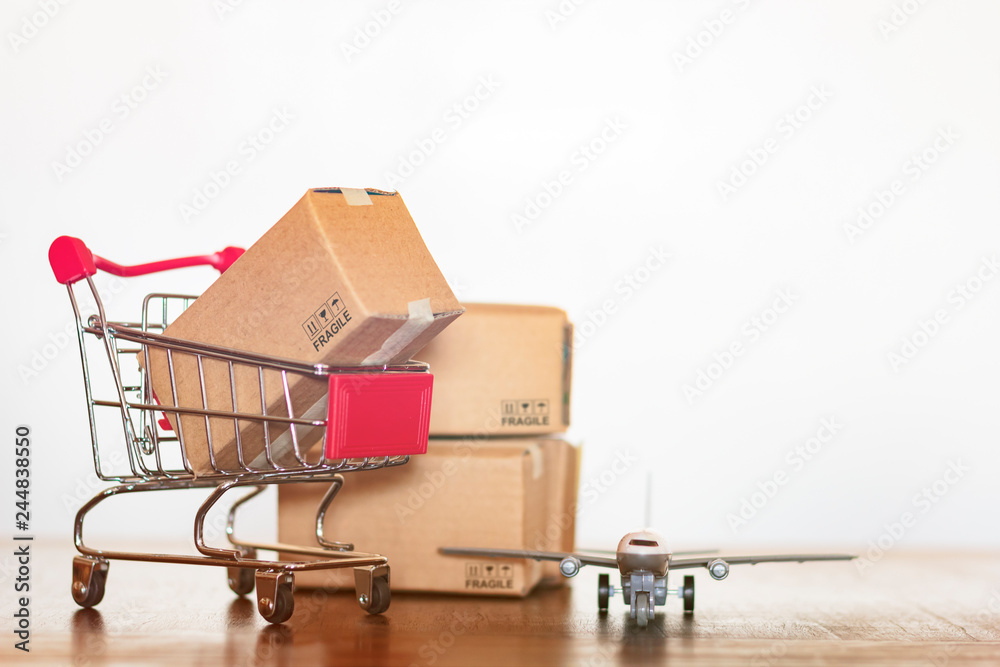 Shopping cart cartons and airplane. International shopping and Worldwide shipping concept