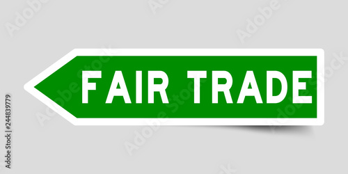 Arrow shape green color sticker in word fair trade on gray background