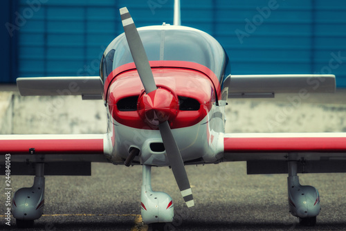 Propeller plane parking at the airport. In front of hangar.