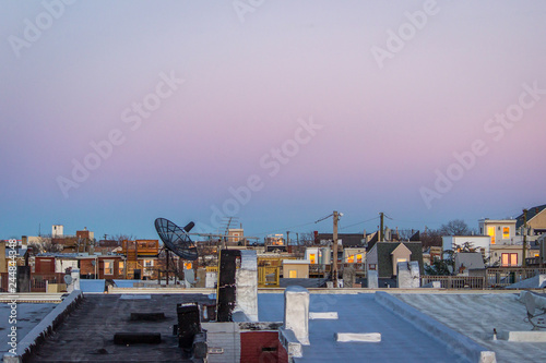 Obraz na plátne Vista of City Rooftops at Sunset - with a Sprawl of Row Houses and Rooftop Porch