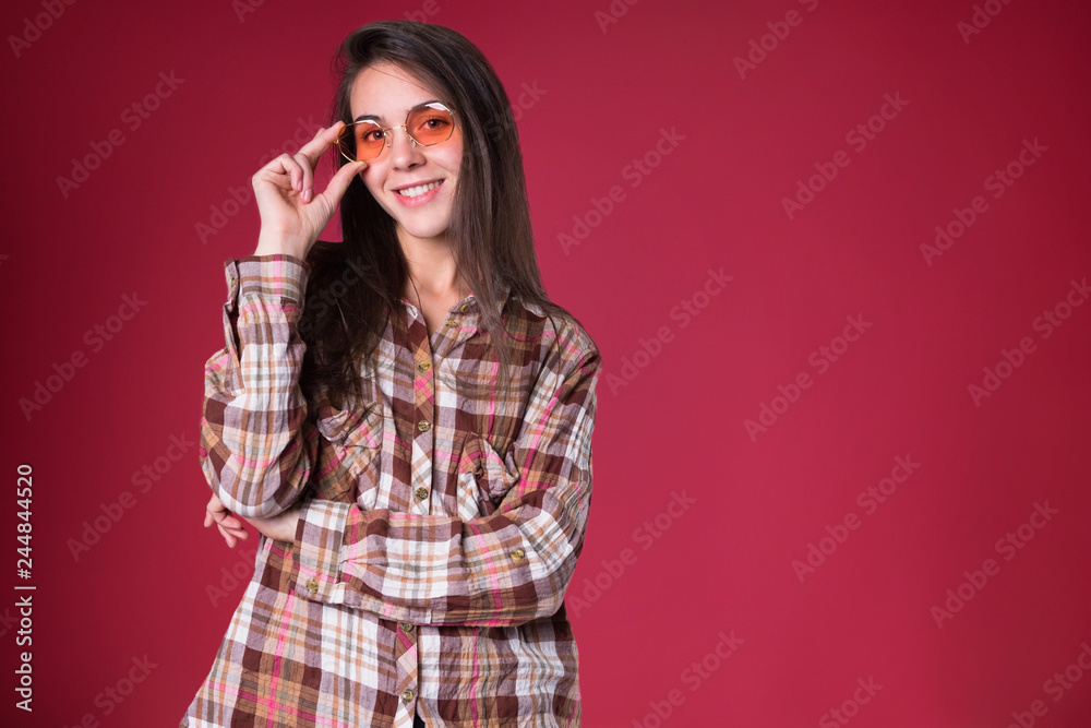 Long haired young brunette stylish girl smiling and laughing on pink background Long haired young brunette stylish girl smiling and laughing on pink background