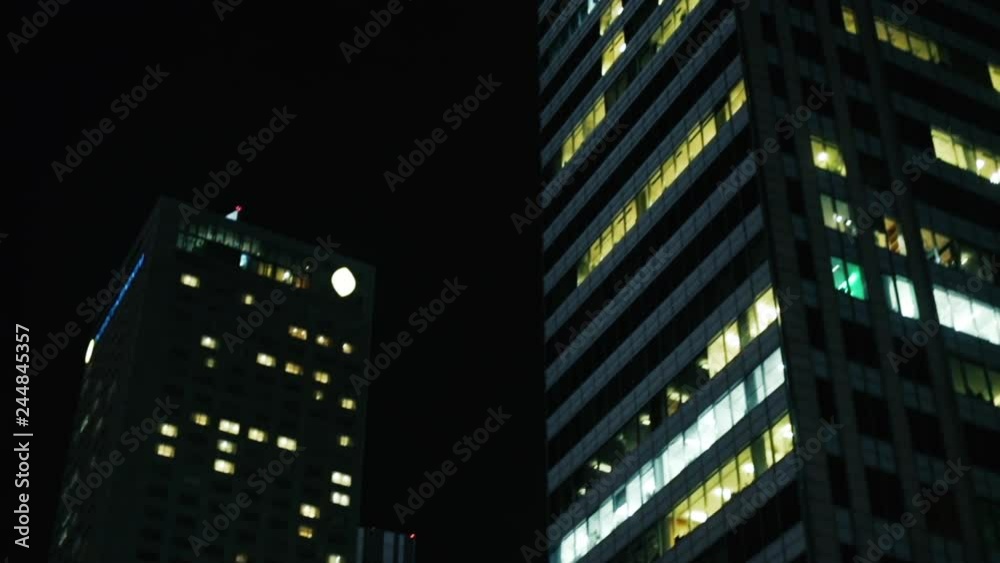 View of skyscrapers with many lighted windows at night. Tall modern office buildings, illuminated windows, people working. Modern night cityscape of Warsaw View of skyscrapers with many lighted windows at night. Tall modern office buildings, illuminated windows, people working. Modern night cityscape of Warsaw