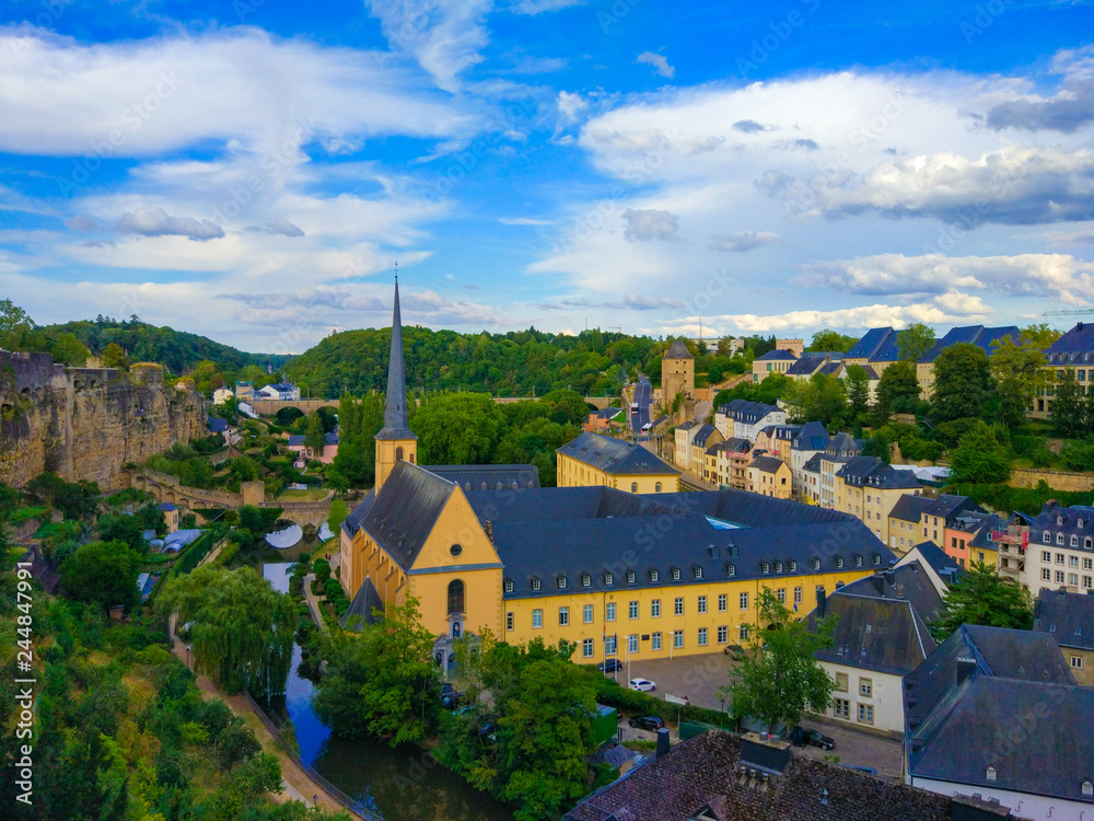 View of the Alzette river in the old town of Luxembourg City, Luxembourg, with St. John Church (church of St. John or St. Jean du Grund) in one side and the wall in other side