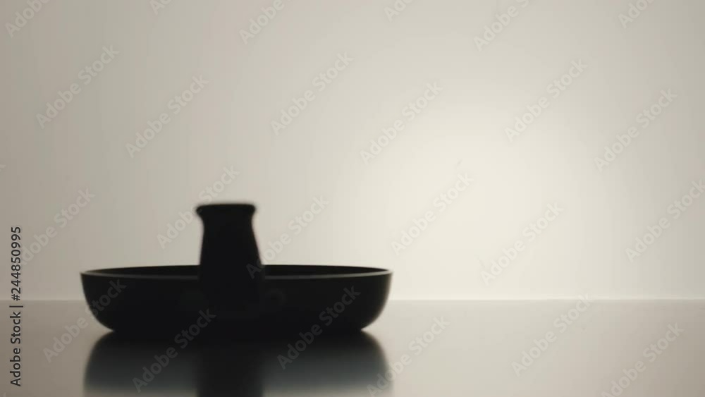 SLOW MOTION: Frying pan is twisting on the white background