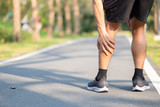 Young fitness man holding his sports leg injury. muscle painful during training. Asian runner having calf ache and problem after running and exercise outside morning. sport and healthy concepts