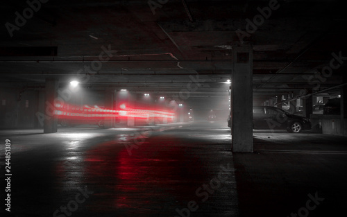 Black, White & Red Colored Long Exposure Photo of Car Lights Driving Through a Parking Garage on a Foggy, Rainy Night  © Jon