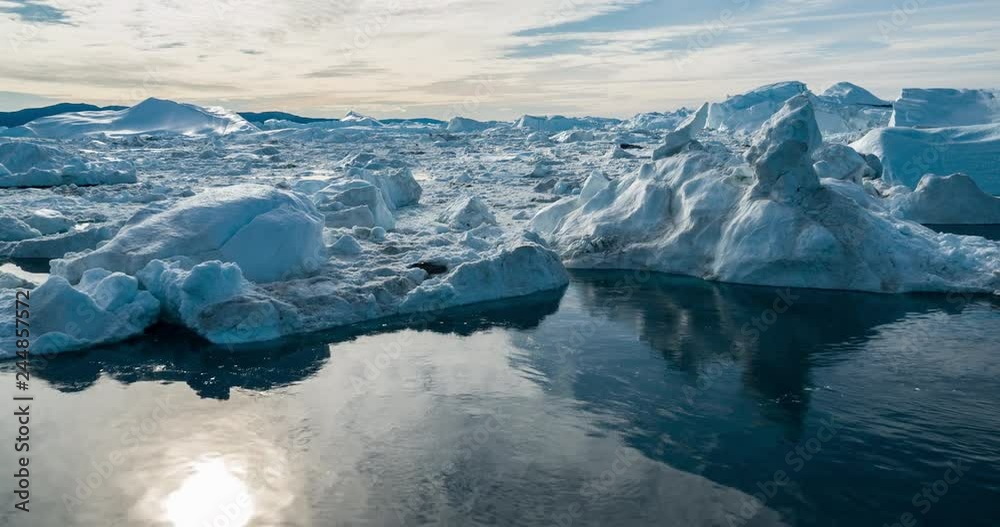 Drone video of Iceberg and ice from glacier in arctic nature landscape on Greenland. Aerial video drone photo of icebergs in Ilulissat icefjord. Affected by climate change and global warming.